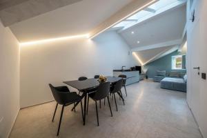 a dining room with a table and chairs and a couch at App 302 Palazzo Cavour in Bolzano