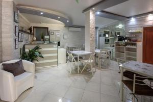 a living room with tables and chairs and a kitchen at Apart & Rooms Fotinov in Burgas