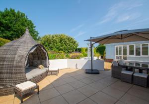un patio con sofá y sombrilla en Denbury House, en Bodham