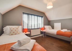 Un dormitorio con dos camas y una ventana. en Denbury House, en Bodham