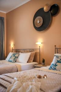 a bedroom with two beds and a fan on the wall at Porto Roma Seaside Studios in Vasilikos
