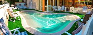 a swimming pool in the middle of a yard at Hotel Gioiosa in Cesenatico