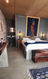 - une chambre avec un lit orné d'une peinture murale dans l'établissement The Desert House, à Uis