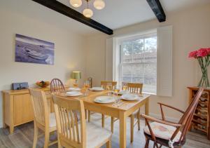 comedor con mesa de madera y sillas en Corner Cottage, en Wells-next-the-Sea