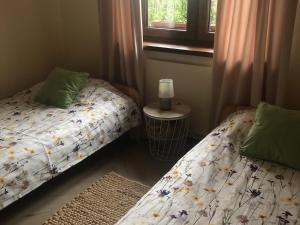 two beds sitting next to each other in a bedroom at Mazurski Domek Brożówka 50 m od plaży in Brożówka