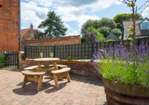una mesa de picnic y dos copas de vino en un patio en Corner Cottage, en Wells-next-the-Sea