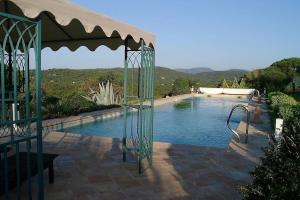 een zwembad met een prieel naast bij Villa 6 chambres, vue inouïe mer et campagne, parc 1 hectare, piscine 20m, climatisation intégrale in Ramatuelle