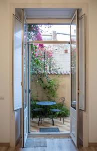eine Glasschiebetür, die auf eine Terrasse mit einem Tisch führt in der Unterkunft B&B Ambitious in Catania