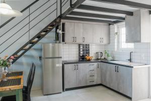 a kitchen with a stainless steel refrigerator and a staircase at Miramare Apartments in Plataniás