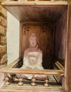 una estatua de un buddha en una caja de madera en Casa Rural Les Avies cerca del mar, en La Nucía