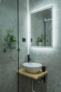 bagno con lavandino bianco e specchio di Miramare Apartments a Plataniás