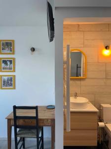 uma casa de banho com um lavatório e uma mesa com um espelho em Maison L'Aiguille - 2 appartements, 5 chambres et table d'hôtes au pied de la montagne à la station de Laye em Laye