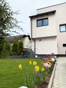 ein Haus mit Blumen im Vorgarten in der Unterkunft Sonnenlay Lounge - Studio & Ferienhaus in Brauneberg