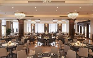 un ristorante con tavoli, sedie e lampadari di Quynh Trang Hung Yen Hotel a HÆ°ng YÃªn