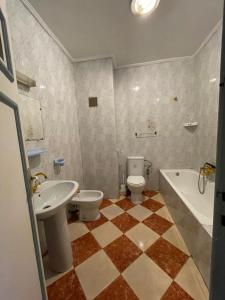 a bathroom with a toilet and a sink and a tub at Complexe Jardins andalouse in Tangier