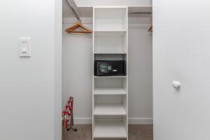 a walk in closet with white walls and white shelves at Modern 2 bed at Beach Walk 17th floor Miami in Hollywood