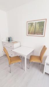 a white table and two chairs in a room at Gemütliche Zweiraumwohnung in Ruhelage in Vienna