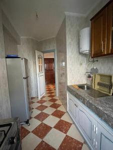 een keuken met een koelkast en een tegelvloer bij Complexe Jardins andalouse in Tanger
