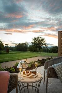 uma mesa com uma garrafa de vinho e copos num pátio em Tewkesbury Park em Tewkesbury