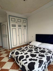 um quarto com um cobertor preto e branco numa cama em Complexe Jardins andalouse em Tânger