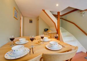 a wooden table with plates and glasses of wine at East Cottage in Corpusty