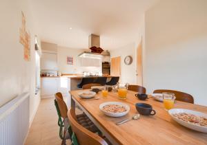 a kitchen with a wooden table with bowls of food at Ellivia House in Mundesley