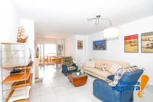 a living room with a couch and a tv at Casa Puig in Comarruga