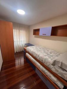um quarto com uma cama e piso em madeira em Estupendo piso en el centro em Cabezón de la Sal