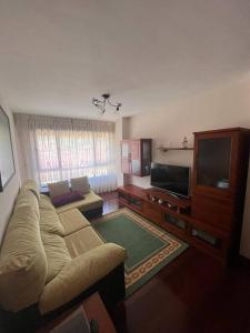 uma sala de estar com um sofá e uma televisão de ecrã plano em Estupendo piso en el centro em Cabezón de la Sal