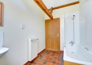 a bathroom with a tub and a toilet and a sink at Farm Cottage in Sidestrand