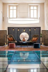 einen Pool in einem Zimmer mit 2 Stühlen und einem Kamin in der Unterkunft Mandarin Oriental, Prague in Prag