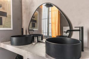 ein Badezimmer mit zwei Waschbecken und einem großen Spiegel in der Unterkunft Outstanding Parisian flat in heart of Paris center in Paris