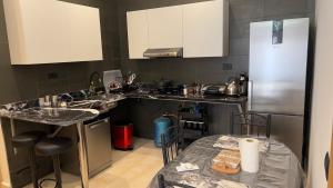 La cuisine est équipée d'un évier, d'un réfrigérateur et d'une table. dans l'établissement Cozy Appartement in a Villa close to Mahaj Riad Rabat, à Rabat