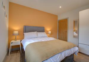 a bedroom with a large bed and two lamps at Field View in Hindolveston