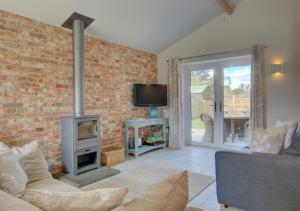 a living room with a brick wall and a fireplace at Field View in Hindolveston