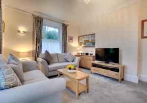 a living room with a couch and a tv at Flat 1 Trent House in Cromer