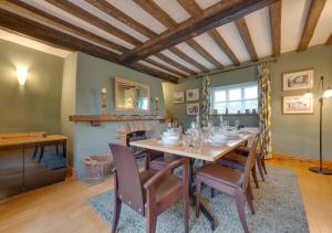 a dining room with a table and a fireplace at Flaxmans Farmhouse in Roughton