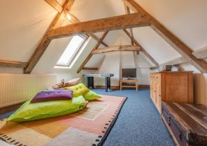 a bedroom with a green bed in the attic at Flaxmans Farmhouse in Roughton