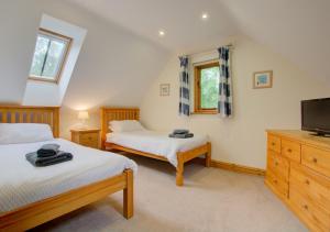 特斯佛特的住宿－Foden Lodge，一间卧室配有两张床和一台平面电视