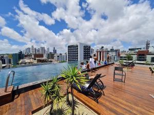 a rooftop deck with a view of a city at Lindos Flats Studios no Qualité in Tambaú