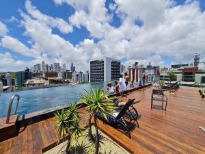 a rooftop deck with a view of a city at Lindos Flats Studios no Qualité in João Pessoa