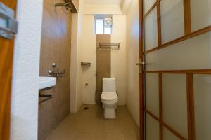a small bathroom with a toilet and a sink at TAG HOTELS in Irugūr