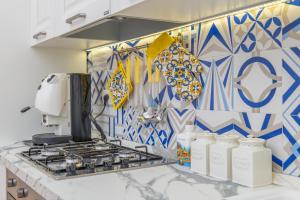 una cucina con piastrelle bianche e blu sul muro di YourHome - Casa Moscatelli 150 steps a Positano