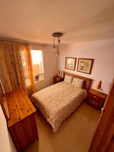Schlafzimmer mit einem Bett, einem Tisch und einem Fenster in der Unterkunft Volcano Beach Views & Wifi in Puerto de Santiago