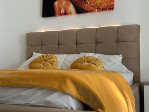 uma cama com cabeceira e duas almofadas em Waves 54 em Mamaia Nord – Năvodari