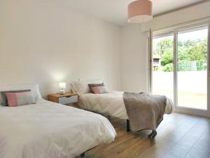 two beds in a white room with a window at Desconectaengalicia Casa A de Lola in Sanxenxo