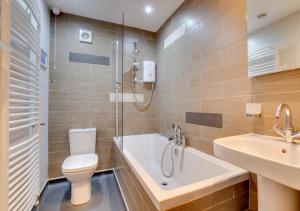 a bathroom with a shower and a toilet and a sink at Green Side Cottage in Thornham +42 photos