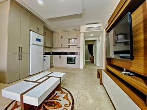 uma grande cozinha com armários brancos e uma televisão em Nokta Ula Suit Apart, Fethiye, Ölüdeniz em Fethiye