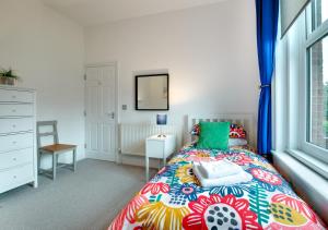 a bedroom with a bed with a colorful bedspread at Happy Valley in Cromer