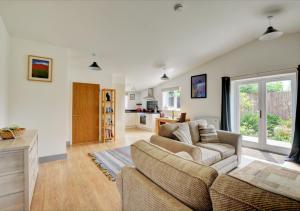 uma sala de estar com um sofá e uma cozinha em Hawthorn Cottage 